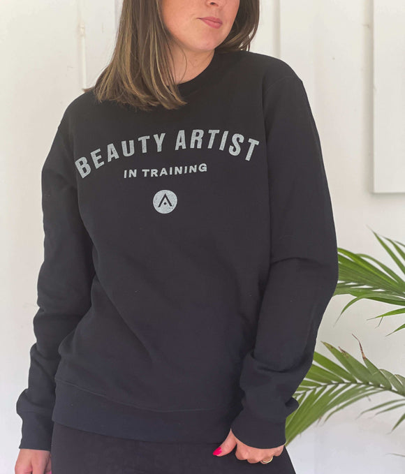 Black "Beauty Artist In Training" fleece sweatshirt made of 80/20% ring-spun cotton/poly, worn by model.