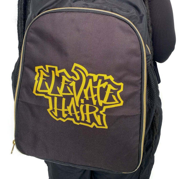 ElevateHair Stylist Backpack with logo, adjustable padded shoulder straps, carrying handle, and multiple pockets, held by a person.