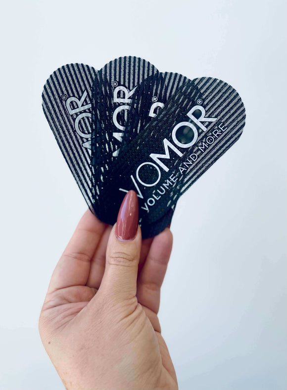 Hand holding VoMor Hair Grippers, pack of 4, for securing hair sections, extensions, and styling without slipping or damage