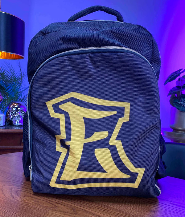 E Stylist Barber Backpack with large "E" logo on wooden table, featuring adjustable straps and multiple pockets.