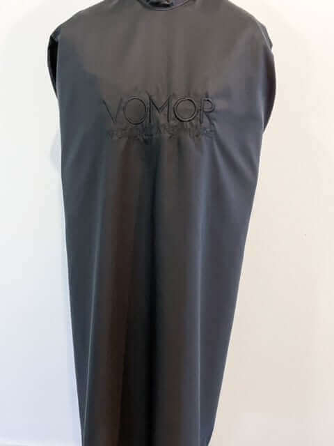 VoMor Blacked Out Cape with embroidered logo, black color, snap buttons at neck, front view.